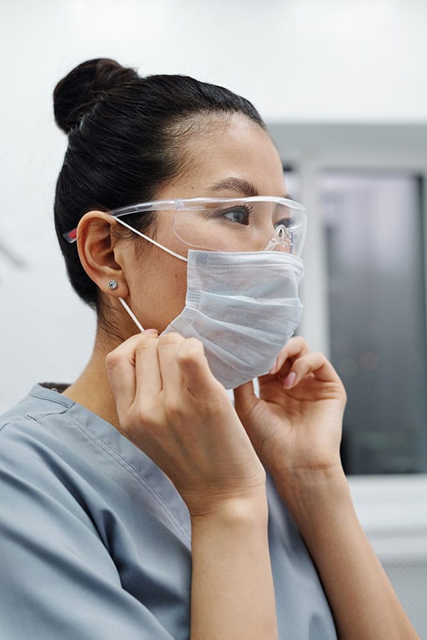 Doctor putting on mask and other PPE to represent the revenue cycle management services for providers in Prescott, Arizona